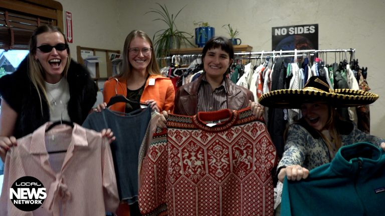 EcoAction Partners leaders holding up used clothing