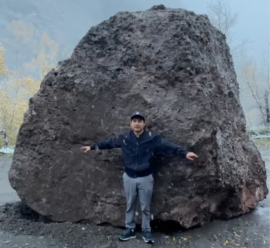 Francisco Sandoval stands in front of the boulder.